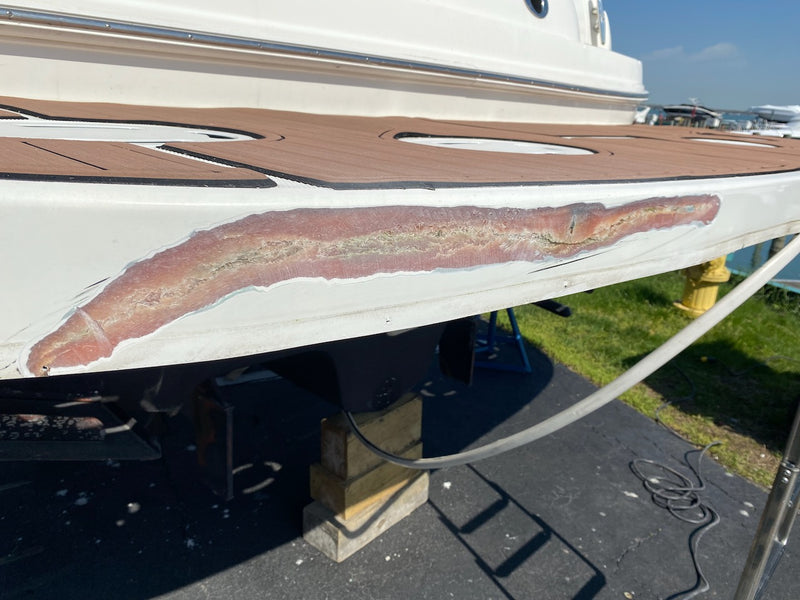 Gouge repair along a boat's side below a teak-style deck