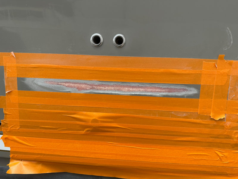 Hull-side gouge ground out and covered with orange masking tape