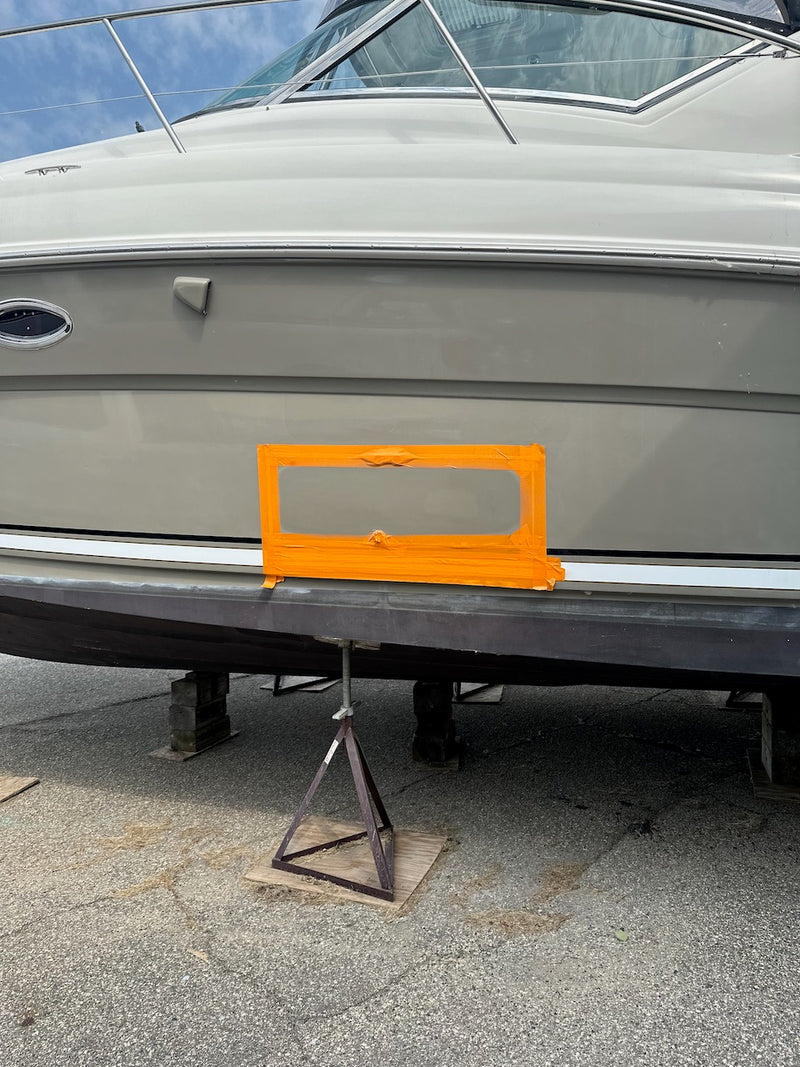 Gray hull side with an orange tape mask around a repair area