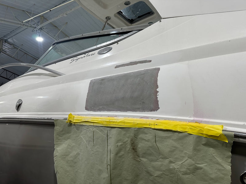 Hull side with the repair patched in gray filler and masked