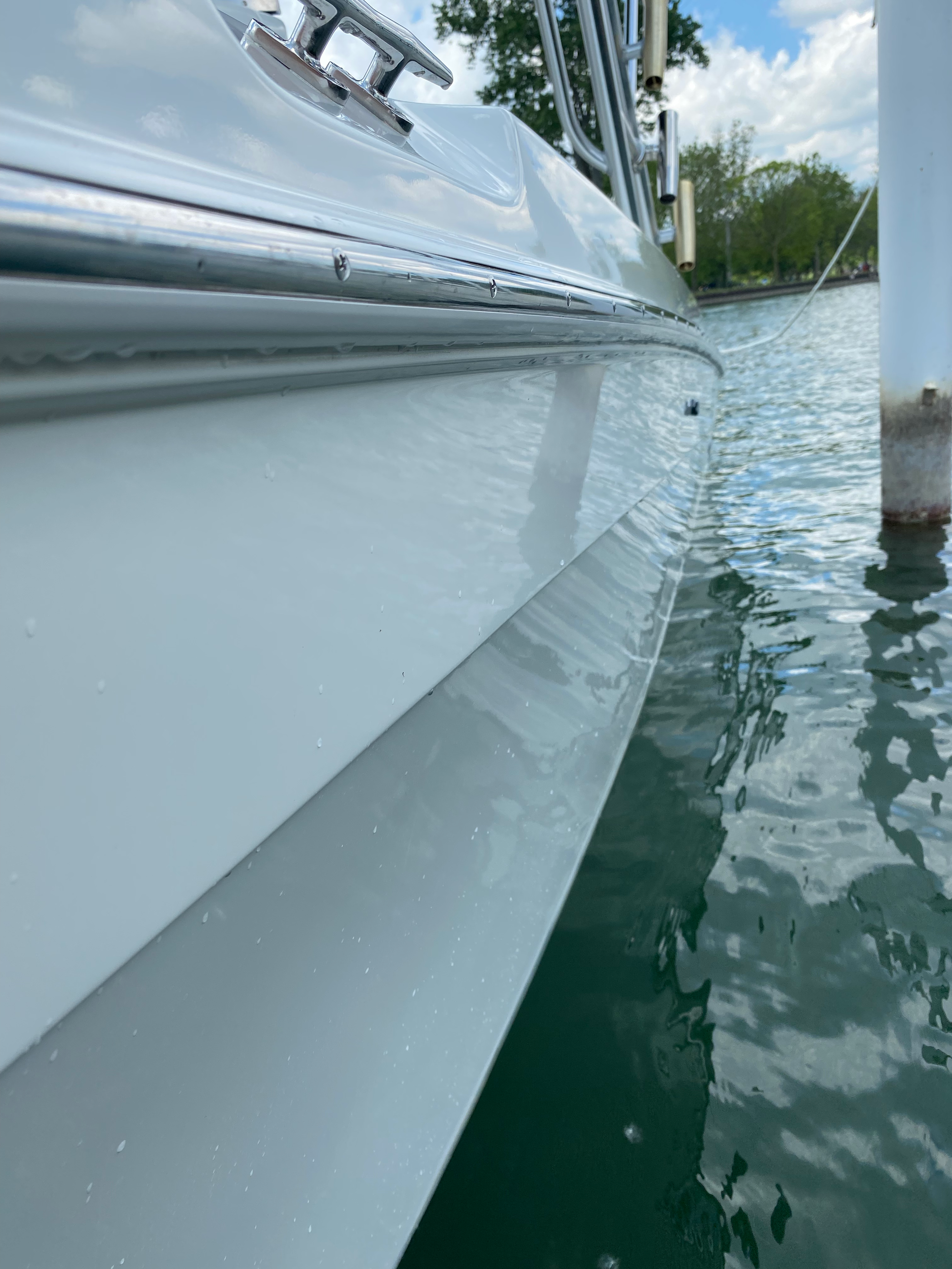 picture of a boats shiny hull side while sitting at the dock